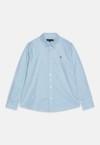 Camisa de botón de manga larga color azul claro, hecha de algodón. Presenta un cuello puntiagudo, botones en la parte delantera y un pequeño logo en el lado izquierdo del pecho.