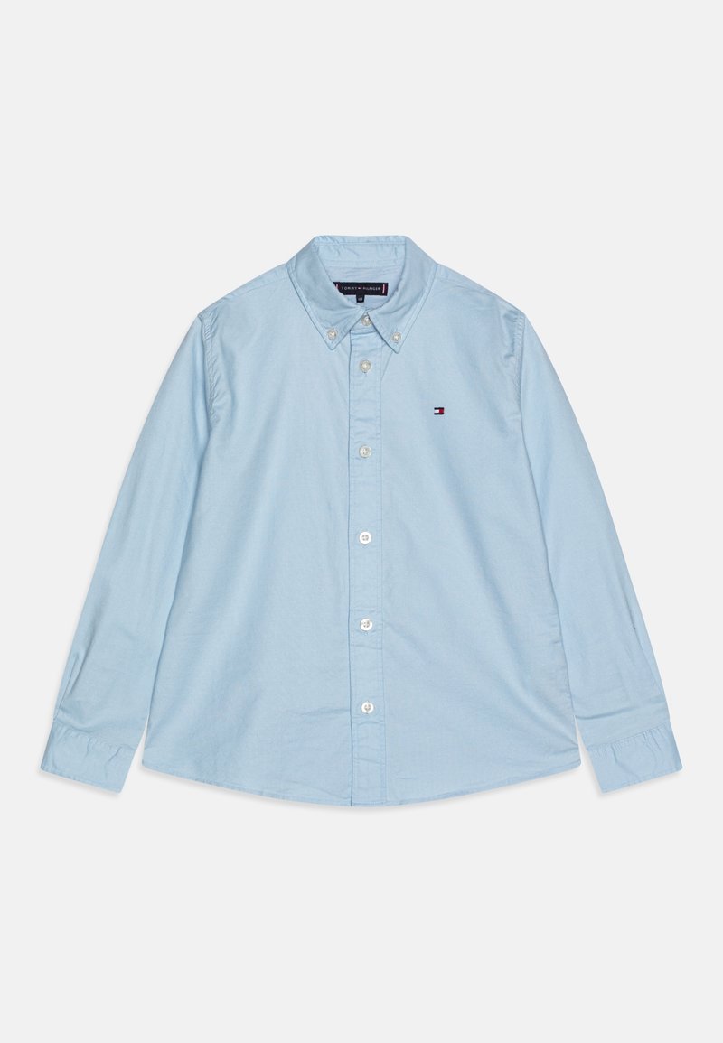 Camisa de botón de manga larga color azul claro, hecha de algodón. Presenta un cuello puntiagudo, botones en la parte delantera y un pequeño logo en el lado izquierdo del pecho.