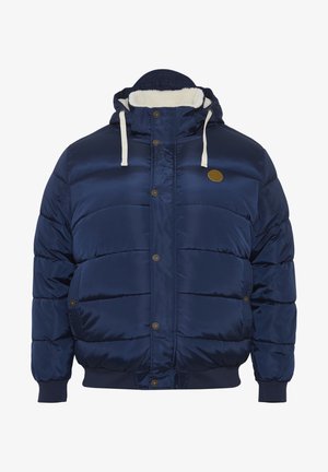 Námořnická modrá péřová bunda s texturovaným povrchem, s kožešinovou podšívkou kapuce, bílými šňůrkami, patentními knoflíky a bočními kapsami.