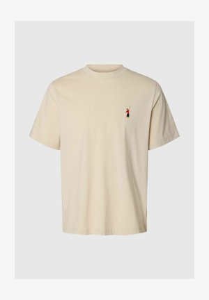 Tricou bej cu mâneci scurte, cu o mică figură brodată reprezentând un jucător de tenis în tricou roșu și pantaloni scurți negri, pe pieptul stâng.