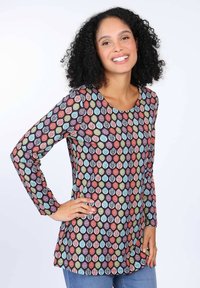 Langärmlige Tunika aus elastischem Material, mit einem mehrfarbigen Blättermuster auf dunklem Hintergrund. Abgerundeter Halsausschnitt und lockere Passform.