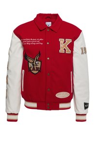Röd och vit varsityjacka med guld accenter, som har broderad text, en örnlogotyp och märken. Knappstängning fram och ribbade ärmslut.