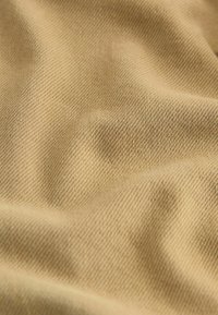 Țesătură de culoare bej deschis, cu o țesătură fină și texturată, care prezintă variații subtile de ton și o suprafață moale și netedă. Ideală pentru îmbrăcăminte sau tapițerie.