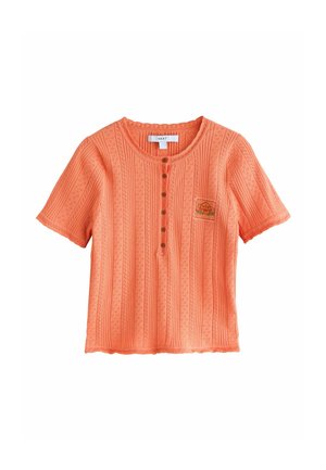 Short-sleeve orange T-shirt with textured vertical stripes, round neckline, and button placket, featuring a small embroidered design on the chest.