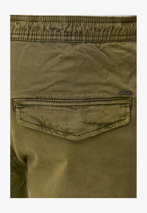 Pantalon en coton extensible vert olive avec une taille froncée, doté d'une poche arrière plate et de détails de couture.