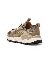 Sneaker bassa con tessuto a righe testurizzato, sovrapposizioni in suede nei toni della terra, suola spessa beige e battistrada in gomma nera resistente.