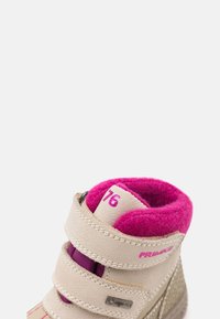 Beżowe skórzane buty z różowym wewnętrznym wykończeniem i dwoma rzepami. Posiadają teksturowane detale po bokach oraz etykietę wodoodporną.