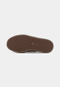 Sola de sapato de borracha com um padrão hexagonal texturizado, apresentando uma cor castanha e uma borda suave e arredondada para durabilidade e tração.