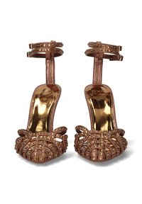 Tacones de color oro rosa con un diseño de rejilla texturizado, adornados con tachuelas doradas y dobles correas en el tobillo con detalles metálicos pulidos.