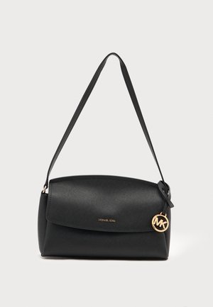 Sac à épaule en cuir noir avec rabat, breloque logo Michael Kors dorée et bandoulière réglable sur un fond clair uni.