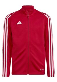 Rote Sportjacke mit Reißverschluss aus glattem Material, die weiße drei-Streifen-Akzente entlang der Ärmel und ein gesticktes Logo auf der Brust aufweist.