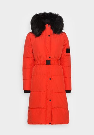 Röd vadderad kappa med avtagbar svart fuskpälsluva, bälte i midjan och svarta detaljer på ärmslut och fickor.