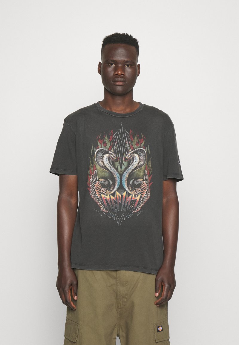 Camiseta de algodón negra con un gráfico frontal de dos serpientes con alas y llamas. Escote redondo y mangas cortas. Ajuste casual.