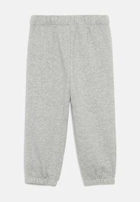 Ljusgråa byxor för småbarn i sweatshirtmaterial med elastisk midja och avslut, utlagda platt mot en vit bakgrund.