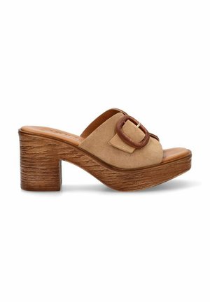 Sandalias deslizantes de ante beige con una correa ancha y una hebilla redonda marrón. Tacón grueso de estilo madera con un acabado texturizado.