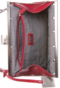 Punainen nahkalaukku, jonka sisällä on mustavalkoinen raitakangasvuori, punainen vetoketjupussi ja hopeiset yksityiskohdat.