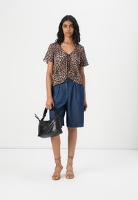 Leopard print short-sleeve top, blue denim shorts, black textured handbag, and tan strappy sandals. Simple and casual ensemble.