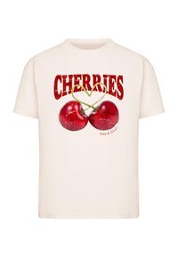 Camiseta crema con un gráfico de dos cerezas rojas con tallos verdes y la palabra "CEREZAS" en letras rojas en negrita arriba.