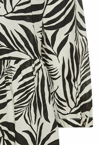 Schwarz-weiß gemustertes Kleid mit einem Blattform-Design, langen Ärmeln und einer gerafften Taille mit Knopfdetail am Bündchen.