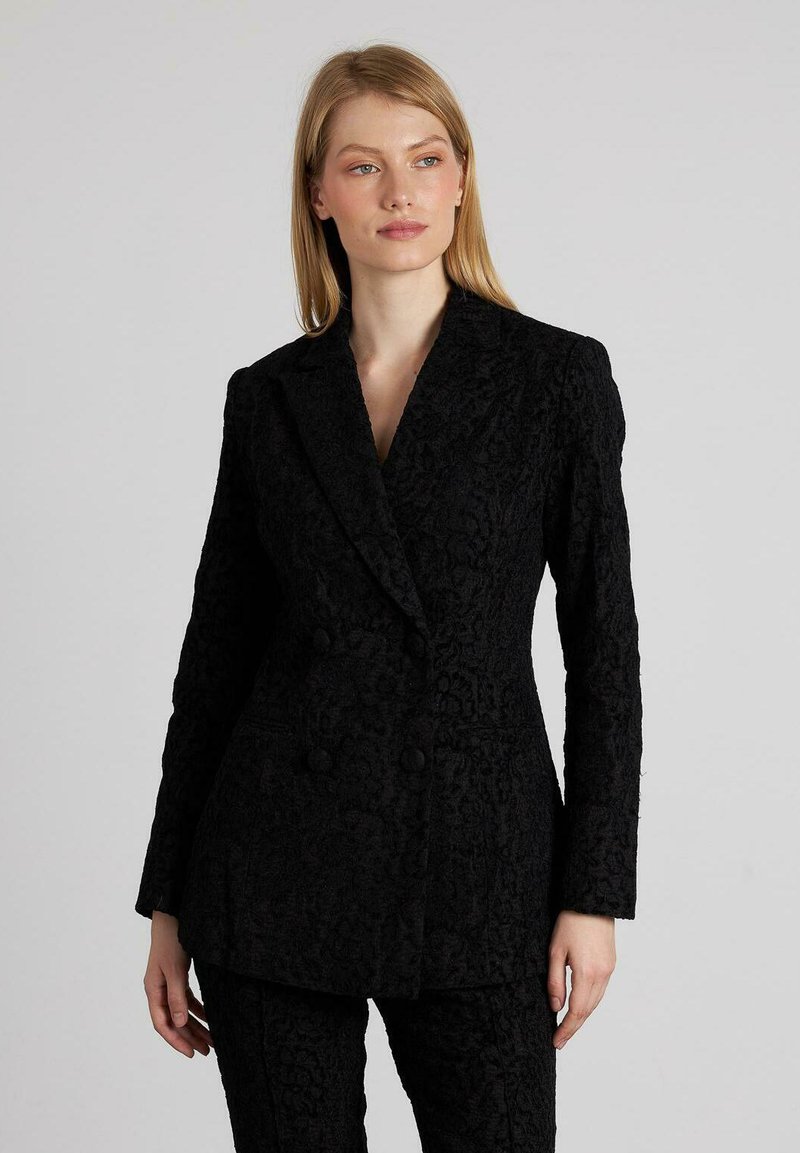 Zwarte dubbelknop blazer van een textuurstof met een subtiel bloemenpatroon, voorzien van een gelapte revers en een getailleerde pasvorm.