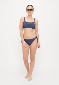 Denim-textuur bikini set in donkerblauw, met een vierkante halslijn, verstelbare bandjes en zijstrikdetails op de bikini onderkant.
