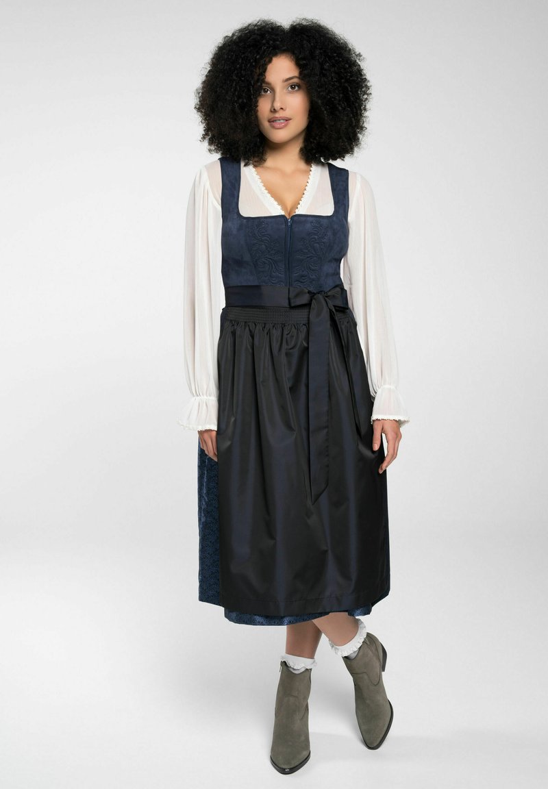 Traditional dress featuring a navy zippered bodice with embroidery, a black satin skirt, and grey ankle boots with a smooth texture.