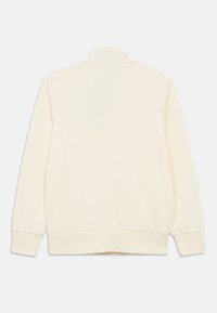 Μακρυμάνικο φούτερ σε κρεμ απόχρωση με ριμπ τελείες στα μανίκια και το τελείωμα, εμφανίζεται από πίσω σε λευκό φόντο.