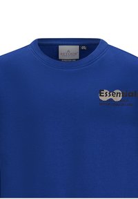 Felpa blu realizzata in tessuto morbido con colletto rotondo. Presenta un dettaglio del logo riflettente, che mette in risalto una texture liscia e un colore uniforme.