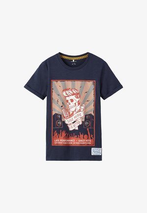 T-shirt bleu marine avec un motif graphique représentant un crâne et un microphone, entouré d'enceintes et du texte « LA MUSIQUE LIVE EST MEILLEURE ». Matière en coton.