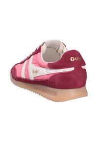 Baskets en daim rose et bordeaux avec des rayures blanches, une doublure intérieure beige et une semelle beige translucide, vues de l'arrière côté droit.