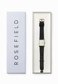 Orologio con cinturino in pelle nera, quadrante rettangolare bianco e dettagli dorati, esposto in una scatola azzurro chiaro con la scritta "ROSEFIELD" stampata sul lato.