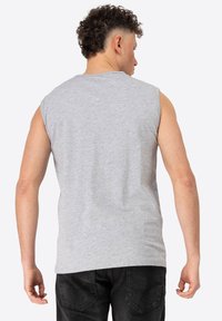 Gray sleeveless t-shirt made of smooth cotton fabric, featuring a round neckline and a relaxed fit, viewed from the back.