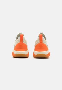Fottøy med mesh-overdel, oransje og beige accenter, teksturert såle, og en logo-detalj på hælen. Har et bånd for enkel påkledning.