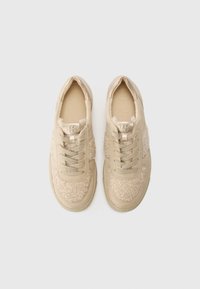 Beżowe tenisówki z teksturowanymi, futrzanymi akcentami i gładkimi panelami ze skóry. Posiadają okrągłe sznurowadła oraz amortyzowaną podeszwę dla komfortu.