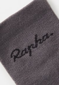 Calzino grigio a maglia con una superficie leggermente testurizzata. Presenta un logo del marchio ricamato in nero, "Rapha", vicino alla parte superiore.