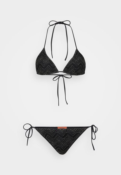 Črni bikini komplet, ki vključuje trikotno haltersko zgornji del z zigzag vzorcem in zavezovanjem, dopolnjen z ujemajočim se bikini spodnjim delom z nizkim pasom in zavezovanjem.