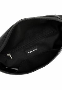 Black handbag interior with smooth fabric, zippered pocket, and Tamaris logo label. Rounded edges, no additional features.