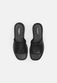 Zwarte leren slidesandalen met een breed kruisriempjesontwerp, gevoerde zool en minimale branding op de binnenzool. Gladde textuur.