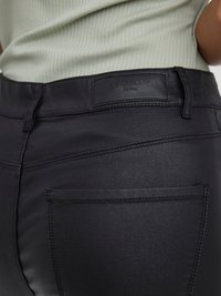Černé džíny z denimu s hladkou texturou a přiléhavým střihem, viditelnou zadní kapsou a koženou nášivkou označenou "Vero Moda Denim."