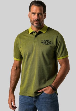 Grünes Polohemd mit einem dunkleren grünen strukturierten Muster, kontrastierender gelber Kragen und Ärmelsäume, mit schwarzem Logo-Text auf der Brust.