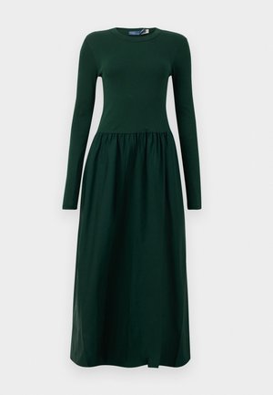 Long-sleeve, dark green dress with a fitted top and flowy, gathered skirt. Made from soft fabric with a round neckline and ankle length.
