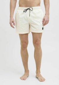 Costumi da bagno da uomo, color crema chiaro, con vita elasticizzata e laccio nero, tasche laterali e piccolo logo sul lato sinistro.