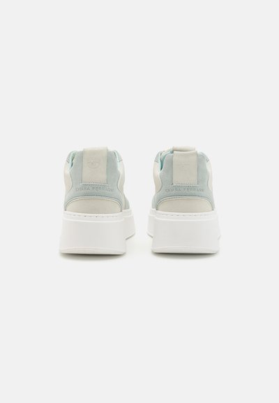 Hvide platform sneakers med en overdel i lyseblå og beige ruskind. Har en pull tab ved hælen og præget branding på bagsiden.