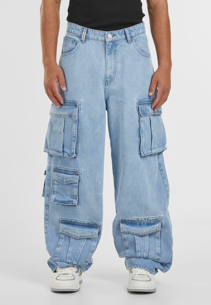 Lys blå denim cargo bukser med flere lommer, avslappet passform, rette ben og oppbrettede kanten. Har kontrastsøm og sølvfargede detaljer.