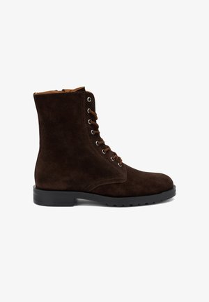 Bottines en daim marron avec un bout arrondi, système de laçage et semelle en caoutchouc. Elles sont dotées d'une fermeture éclair et de détails en surpiqûre.