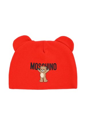 Bonnet en coton rouge avec oreilles d'ours, comportant un graphique d'ours et le texte "MOSCHINO" imprimé en noir. Texture douce et forme arrondie.