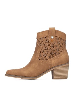 Botín de gamuza color canela con patrón floral recortado, punta puntiaguda y tacón apilado. Cuenta con una lengüeta lateral con un adorno de botón decorativo.