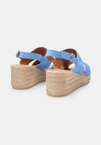 Sandali con tacco a cuneo blu in suede, con cinturino alla caviglia regolabile, suola in texture di sughero e dettagli rigati sulla piattaforma.