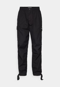Pantalon cargo noir avec taille élastique, fermeture par bouton, poches latérales et cordons réglables aux chevilles.