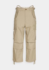 Beiga cargobyxor med hög midja, flera sidofickor och justerbara remmar. Tillverkade av bomullsmaterial, med en jämn textur.